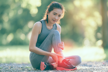 Young Asian Sportswoman Resting in Sunlit Park After Run