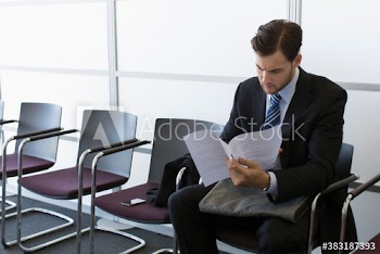 Young businessman reviewing resume in office lobby