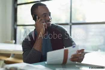 Young businessman talking on smart phone in office