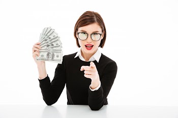 Young businesswoman showing money and pointing with finger Free Photo