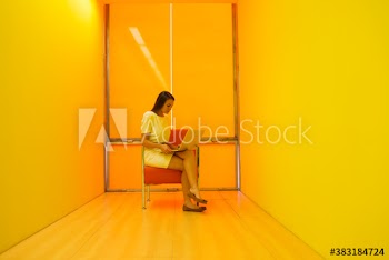 Young businesswoman using laptop in modern yellow office