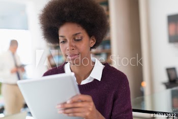 Young businesswoman with afro using digital tablet