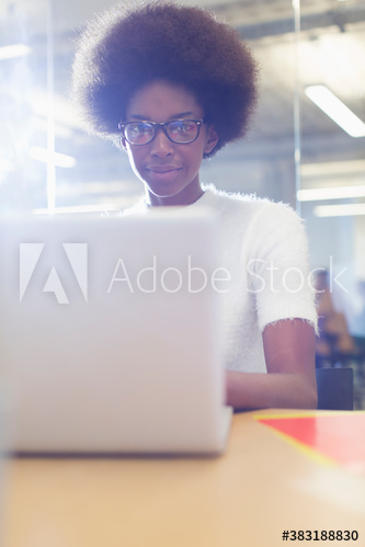 Young businesswoman with afro working at laptop in office