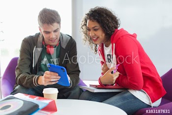 Young college students with digital tablet studying in student lounge