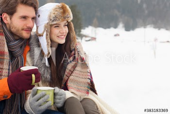 Young couple drinking coffee in snow