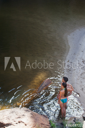 Young couple in bathing suits at lakeside