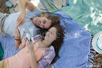 Young couple playing cards on blanket