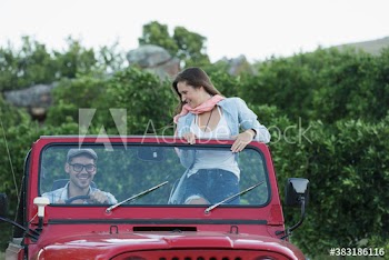 Young couple riding in jeep