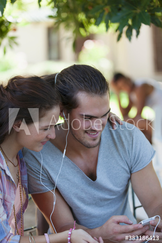 Young couple sharing headphones listening to music