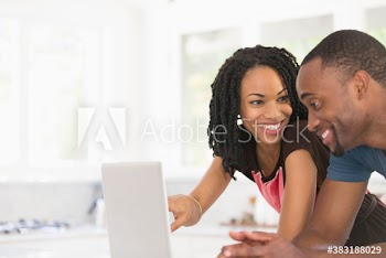 Young couple using laptop in kitchen