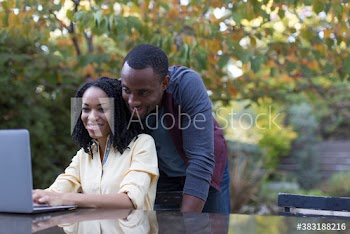 Young couple using laptop on autumn patio