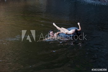 Young couple with inner tube on lake