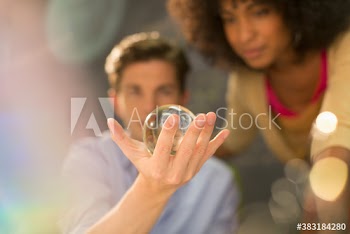 Young creative business people examining orb in office