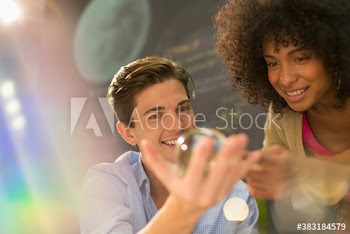 Young creative business people examining orb in office