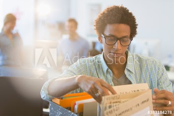 Young creative businessman looking at files in office