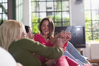 Young female roommates fighting over remote control
