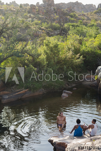 Young friends swimming and relaxing at pond