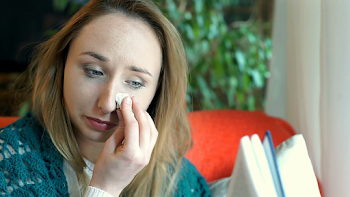 Young girl crying while reading very sad book, steadycam shot ...