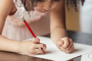 Young Girl Drawing On Paper