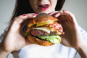 Young lady holding huge burger 