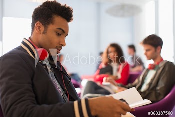 Young male college student studying in student lounge