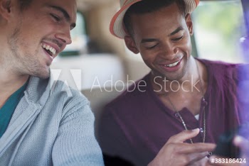Young male friends using smart phone in van