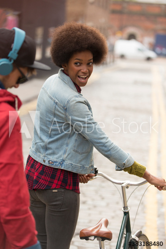 Young man and woman with bicycle on city street