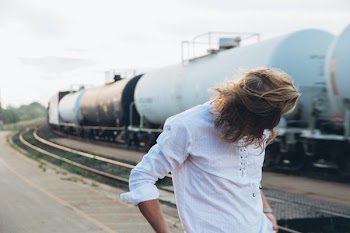 Young Man By Trains At Sunset