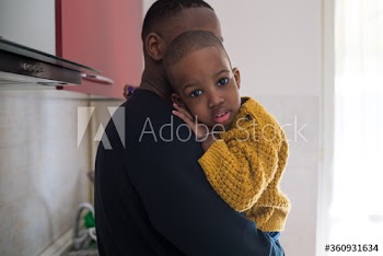 Young man carrying his son at home