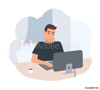 Young man sitting at desk and surfing internet on computer