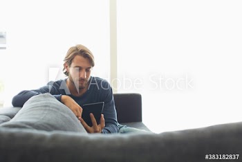 Young man using digital tablet on sofa