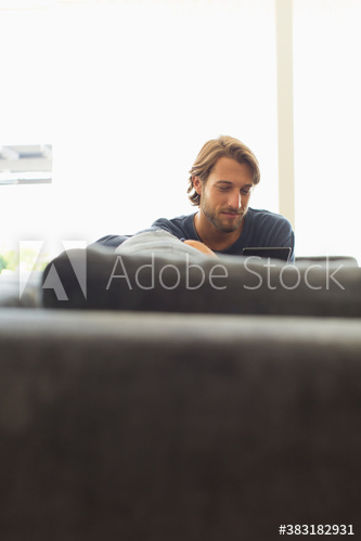 Young man using digital tablet on sofa