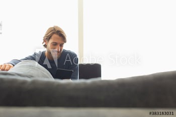 Young man using digital tablet on sofa
