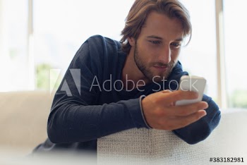 Young man using smart phone on sofa