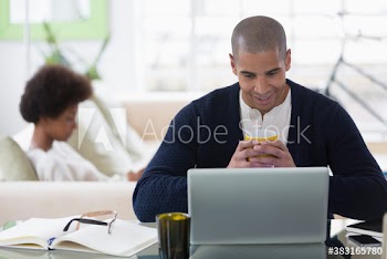Young man with coffee working from home at laptop