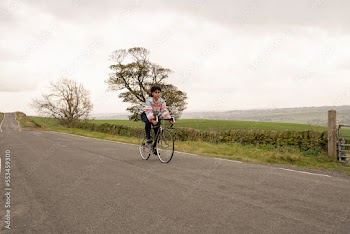 Young woman cycling on rural road