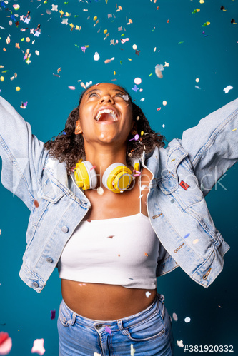 Young woman dancing while spreading confetti