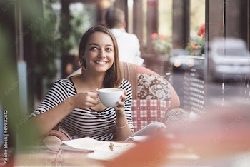 Young woman drinking coffee in urban cafe
