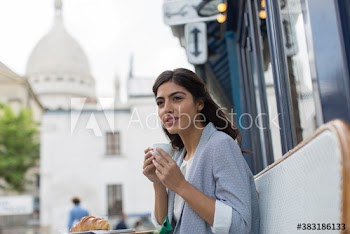 Young woman enjoying espresso at sidewalk cafe, Montmartre, Paris