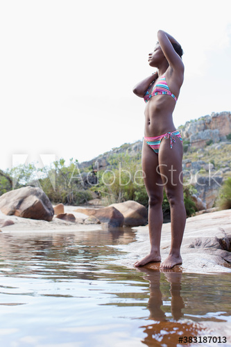 Young woman in bikini relaxing at lake