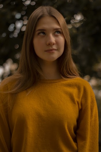 Young Woman in Orange Top With Her Eyes Looking Up