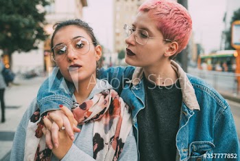 Young woman looking at her friend while walking on street