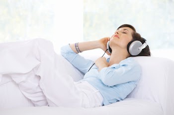 Young woman on couch and listen to the music