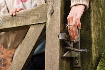 Young woman opening gate while hiking