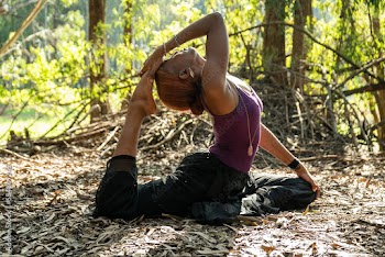 young woman practicing one legged pigeon pose in nature