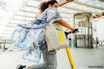 Young woman riding electric scooter on street