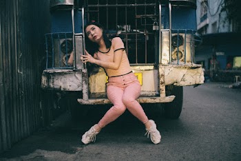 Young Woman Sitting On The Step Board At The Back Of An Old Jeep