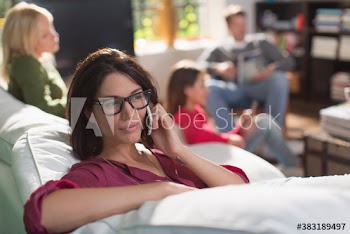 Young woman talking on smart phone on sofa