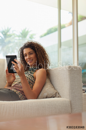 Young woman using digital tablet on sofa