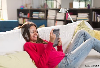 Young woman using digital tablet on sofa